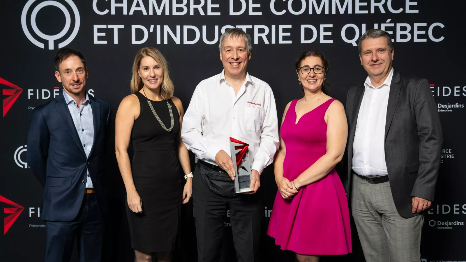 Przedstawiciele firmy InnovMetric na scenie z dumą odbierają nagrodę Prix Rayonnement Hors Québec.